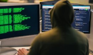 Persona ante un ordenador que representa los delitos informáticos más comunes en España y sus penas.